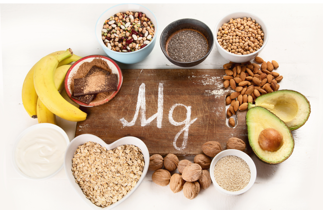 The chemical symbol Mg surrounded by bananas walnuts almonds and pumpkin seeds containing magnesium which benefits after 50